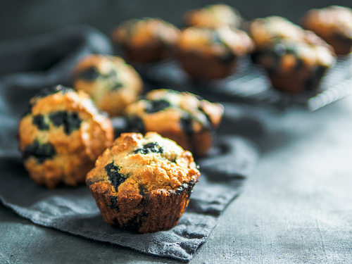 Homemade vegan blueberry muffins on dark background. Copy space for text or design. Low key