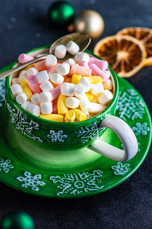 Glass with christmas cocoa drink with marshmallow on stone background with copy space