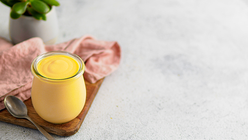 Yellow mango lassi on gray background. Indian mango yogurt drink with copy space left.