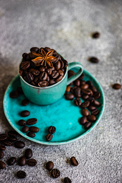 Ceramic cup and coffee beans on stone background with copy space as a coffee concept