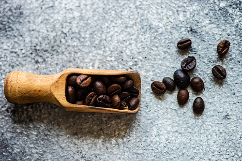 Vintage wooden spoon with coffee beans as a morning coffee concept with copy space