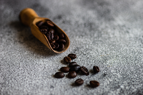 Vintage wooden spoon with coffee beans as a morning coffee concept with copy space