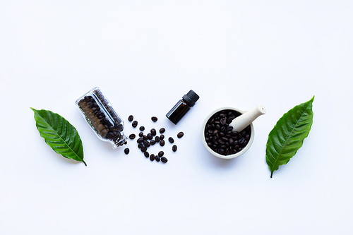 Glass bottle with essential oil of coffee on white background