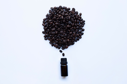 Glass bottle with essential oil of coffee and Coffee grains on white background