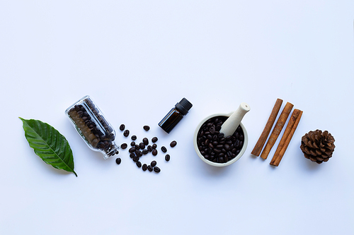 Glass bottle with essential oil of coffee on white background