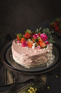 Strawberry cake, strawberry sponge cake with fresh strawberries and sour cream on a dark background.