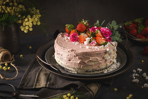 Strawberry cake, strawberry sponge cake with fresh strawberries and sour cream on a dark background.
