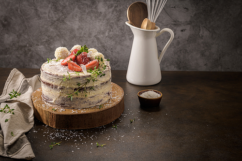 Naked cake with strawberries on kitchen counter top.