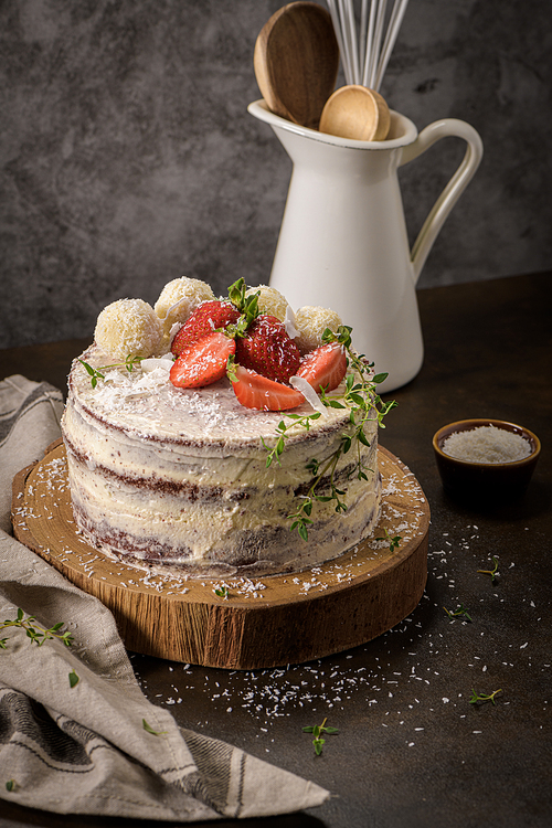 Naked cake with strawberries on kitchen counter top.