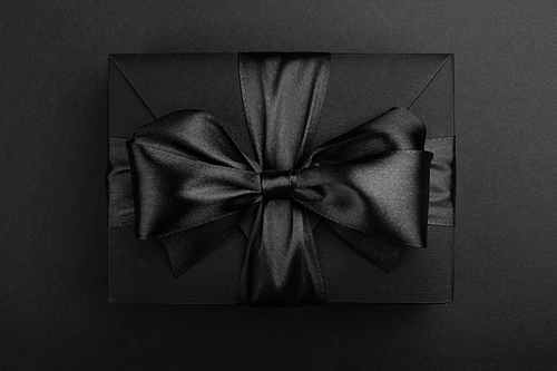 Black friday sale box gift present with ribbon bow on black conceptual design