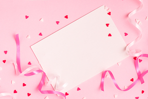 Delicate pink party background with streamers for celebrating with scattered confetti