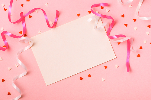 Delicate pink party background with streamers for celebrating with scattered confetti