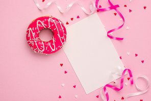 Donuts with icing on pastel pink background with copyspace. Sweet donuts.