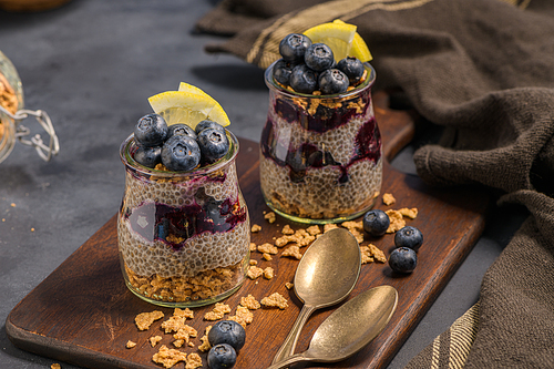 Chia pudding with blueberries on dark table.