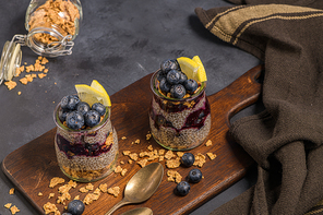 Chia pudding with blueberries on dark table.