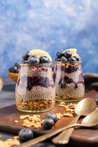 Chia pudding with blueberries on dark table.
