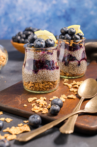 Chia pudding with blueberries on dark table.