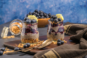 Chia pudding with blueberries on dark table.