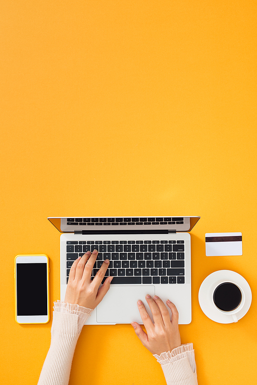 Woman hands typing on computer; people and technology concept; top view, selective focus.