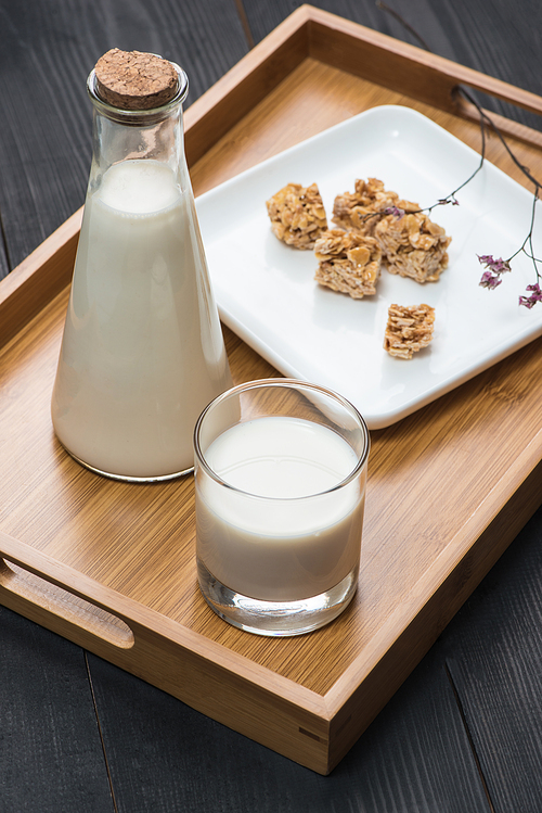 Dairy products. A bottle of milk and glass of milk serve with almond candies on a rustic wooden table.