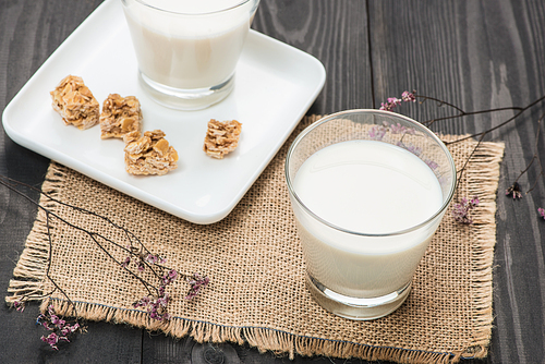 Dairy products. A glass of milk serve with almond candies on a rustic wooden table.