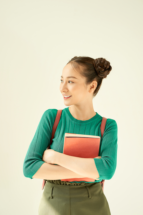 Portrait of a gorgeous young student girl holding exercise books.
