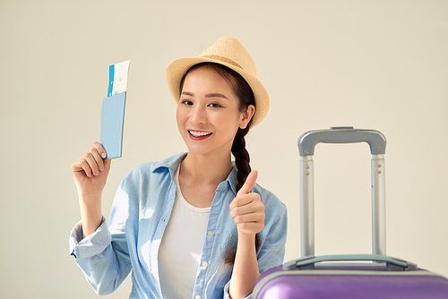 Young asian woman holding a passport isolated smiling and raising thumb up