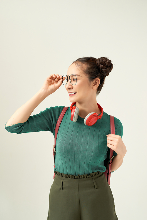 Happy cute young student girl portrait in glasses with backpack on white background