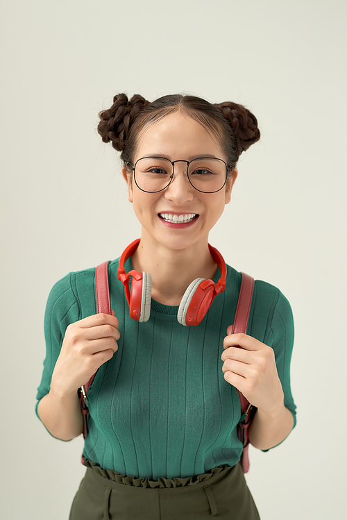 Happy cute young student girl portrait in glasses with backpack on white background