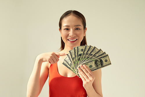 Photo of rich woman in basic clothing holding fan of dollar money isolated over light background
