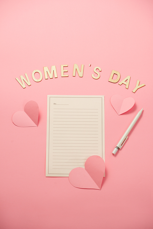 Happy Woman's Day message with heart paper on coral paper background