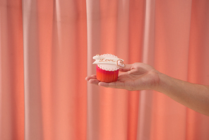 Valentine sweet love cupcake in hand on light background