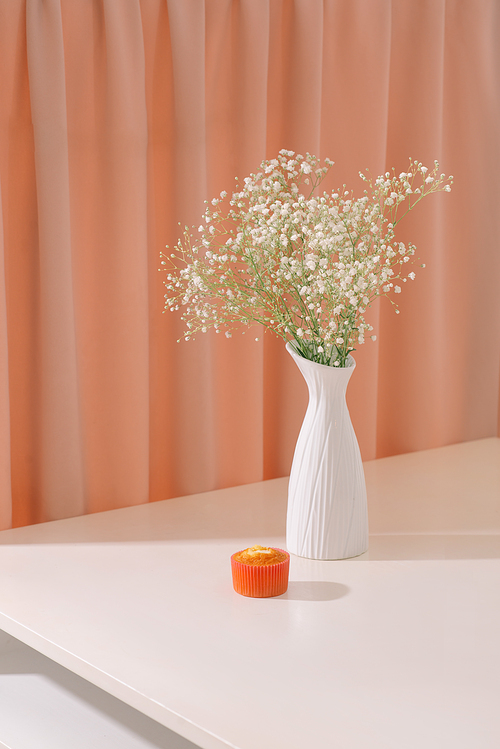 Gypsophila (Baby's breath flowers), in bottle on textured background. Beautiful light, airy masses of small white flowers. floral still life as Interior decoration concept.