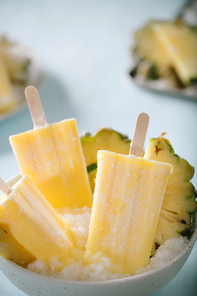 Some homemade Pineapple Popsicles (selective focus) on a rustic background