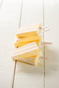 Old and rustic wooden table with homemade Pineapple Pipsicles (selective focus; close-up shot)