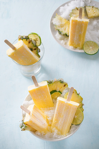 Some homemade Pineapple Popsicles (selective focus) on a rustic background