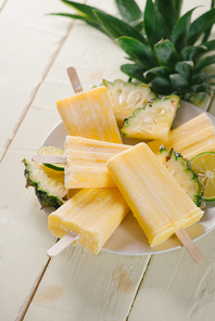 Old and rustic wooden table with homemade Pineapple Pipsicles (selective focus; close-up shot)