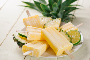 Old and rustic wooden table with homemade Pineapple Pipsicles (selective focus; close-up shot)