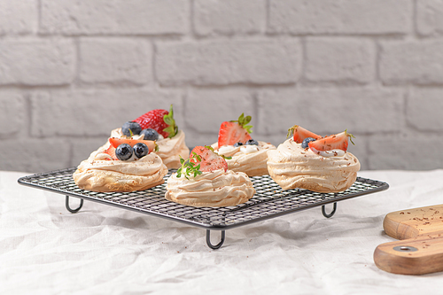 Small pavlova cakes with fresh raspberries and blueberries.