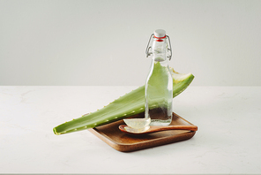 Aloe pieces, fresh leaves and bottle glass on a white background