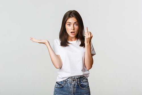 Confused and pissed-off brunette girl arguing about wedding, showing finger without ring.