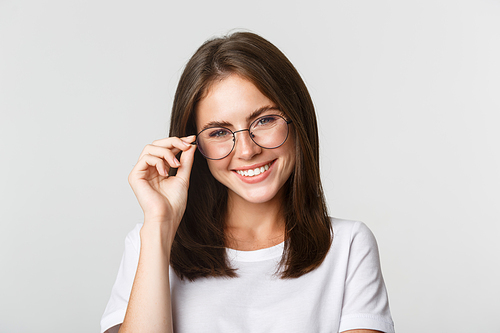 Close-up of smiling confident, beautiful brunette girl in glasses looking happy.