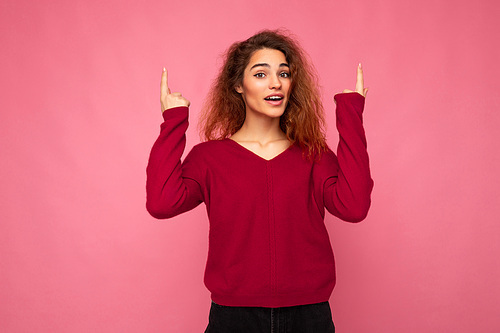 Photo of pretty astonished young woman pointing fingers up at copyspace presenting incredible ads promo with impressed scream wow omg emotions wearing good look outfit isolated over background with free space.