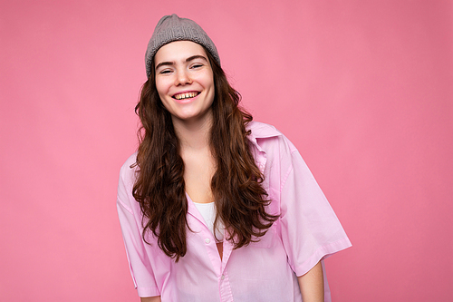 Photo of young positive happy smiling beautiful woman with sincere emotions wearing stylish clothes isolated over background with copy space.