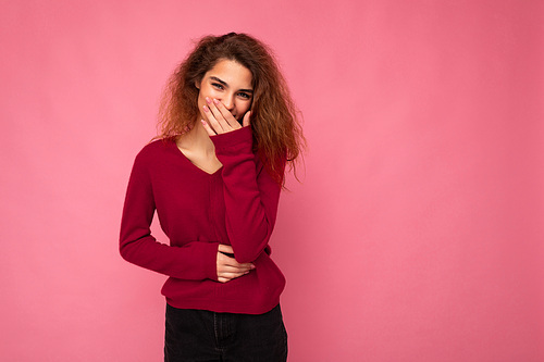 Photo of young happy positive pretty nice brunette wavy woman with sincere emotions wearing casual pink sweater isolated over pink background with empty space and laughing.