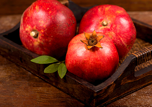 Ripe pomegranate fruits on the wooden background. Top view.