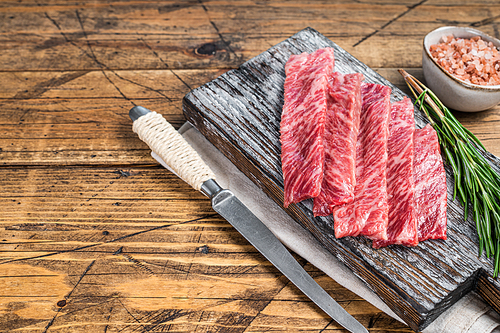 Premium Rare Slices of Wagyu A5 beef with high marbled texture. wooden background. Top view. Copy space.