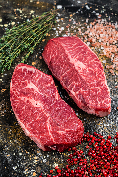 Raw Shoulder Top Blade cuts, beef meat steaks. Brown background. Top View.