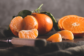 Fresh mandarin oranges or tangerines with leaves on textured dark background