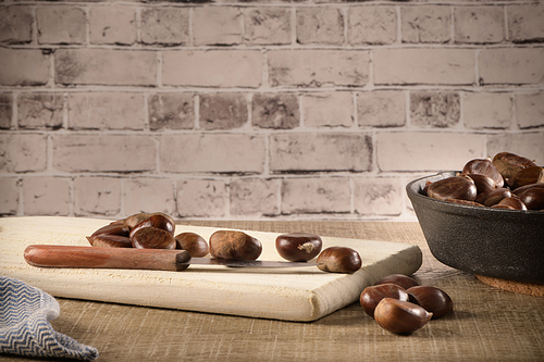 Chestnuts on wooden cutting board.